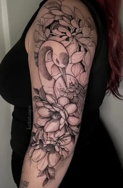 Tatuaje fine line con puntillismo de cisne entre peonías y hojas, media manga en el brazo de mujer, hecho en Recoleta, Buenos Aires