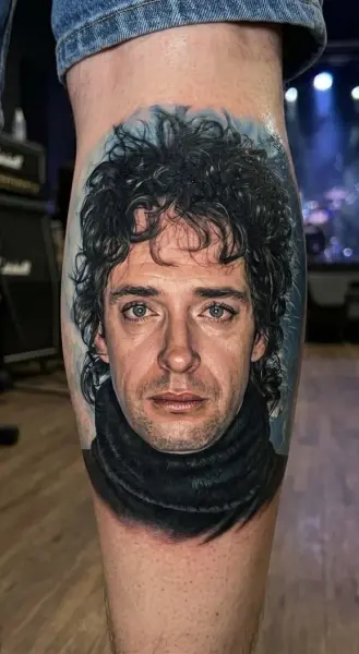 Retrato realista a color de Gustavo Cerati en la pantorrilla